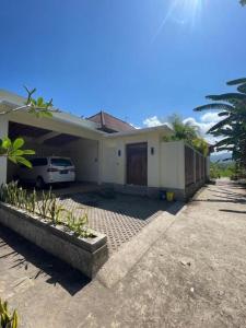 a house with a car parked in front of it at Sandz House in Jembrana