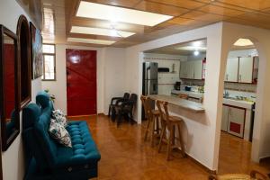 a living room with a blue couch and a kitchen at Merakihouse in Santa Rosa de Cabal