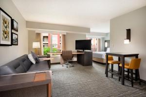 a hotel room with a couch and a bed and a desk at Residence Inn Indianapolis Downtown on the Canal in Indianapolis