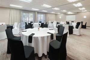 a conference room with white tables and black chairs at Courtyard by Marriott Atlanta Executive Park/Emory in Atlanta