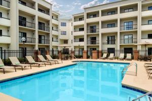 a swimming pool with chairs and a hotel at Courtyard by Marriott Atlanta Executive Park/Emory in Atlanta