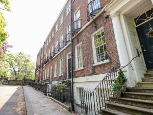 a brick building with stairs next to a street at St John's North Hotel Apartments in Wakefield