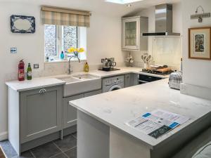 a kitchen with a sink and a counter top at Cobble Stones in Holt