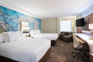 a hotel room with two beds and a desk at Courtyard Miami Downtown Brickell Area in Miami