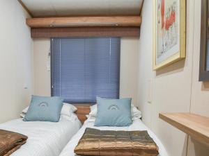 2 Betten in einem Zimmer mit Fenster in der Unterkunft Lodge 69 in Stonham Aspall