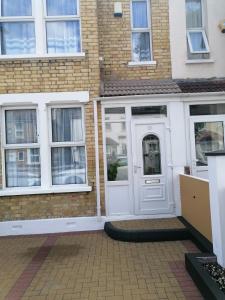 a white door on a brick building with windows at FBS Homestay in Norwood