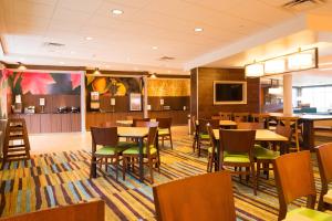 una sala da pranzo con tavoli, sedie e TV di Fairfield Inn & Suites by Marriott Dickson a Dickson