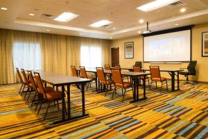 una sala de conferencias con mesas y sillas y una pantalla de proyección en Fairfield Inn & Suites by Marriott Dickson, en Dickson