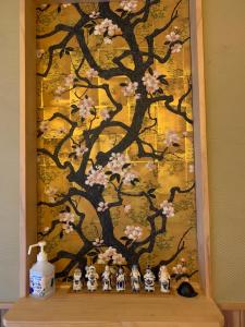 翠云間 庭院式京町屋 京都四条西院 في كيوتو: لوحة شجرة عليها تماثيل على رف