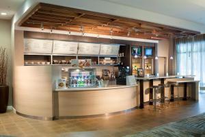 a bar in a restaurant with a counter and stools at Courtyard by Marriott Palm Beach Jupiter in Jupiter