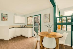 - une cuisine avec une table en bois et des chaises blanches dans l'établissement Sparkling Waters Unit 1, à Gold Coast
