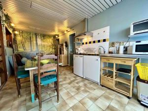 a kitchen with a table and a table and chairs at Maison de village à St-Pierre-d'Oléron - 2 pièces, 3 couchages, centre, proche commerces et pistes cyclables - FR-1-246A-270 in Saint-Pierre-dʼOléron