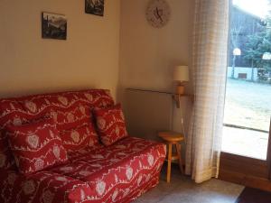 ein Wohnzimmer mit einem roten Sofa und einem Fenster in der Unterkunft Studio Autrans-Méaudre en Vercors-Autrans, 1 pièce, 4 personnes - FR-1-737-53 in Autrans