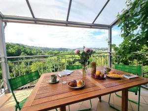 einen Holztisch mit Essen auf dem Balkon in der Unterkunft Appartement Saint-Genest-Lerpt, 3 pièces, 4 personnes - FR-1-496-287 in Saint-Genest-Lerpt