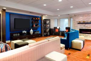 a living room with couches and a flat screen tv at Courtyard by Marriott Myrtle Beach Barefoot Landing in Myrtle Beach