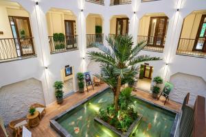 uma piscina interior com uma palmeira num edifício em Little Oasis - An Eco Friendly Hotel & Spa em Hoi An