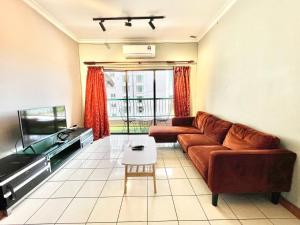 sala de estar con sofá y TV de pantalla plana en MARINA COURT VACATION HOME 3 BEDROOMS - Kota Kinabalu, en Kota Kinabalu