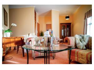 a living room with a table and a piano at Hotel Fenix in Jelenia Góra