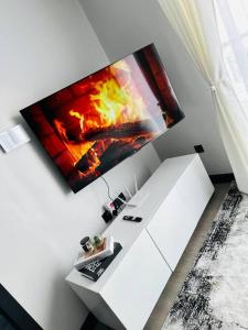 a tv hanging on a wall with a fireplace at Modern home in Nairobi Escada in Nairobi