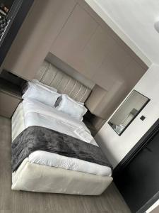 1 dormitorio con 1 cama grande con sábanas y almohadas blancas en Modern home in Nairobi Escada en Nairobi