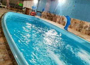 a swimming pool with a blue water slide at Casa de campo Maria&Maria próximo a cidade de Juiz de Fora MG in Juiz de Fora
