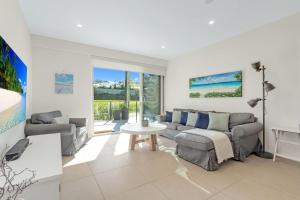 una sala de estar con un sofá y una mesa en Le Maison at the Beach, en Huskisson