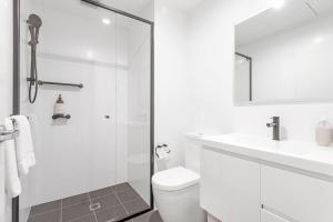 Un baño blanco con ducha y WC. en Le Maison at the Beach, en Huskisson