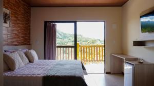 una camera da letto con un letto e una grande finestra di POUSADA KALUKA a Bezerros Altre 72 foto