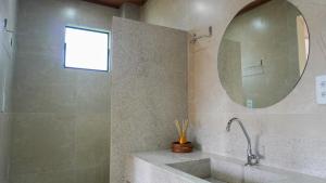 La salle de bains est pourvue d'un lavabo et d'un miroir. dans l'établissement POUSADA KALUKA, à Bezerros