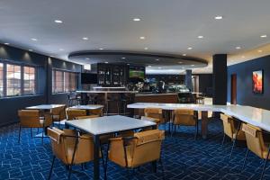 a restaurant with tables and chairs and a bar at Courtyard by Marriott Scottsdale Old Town in Scottsdale