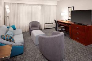 um quarto de hotel com uma secretária e uma sala de estar em Courtyard by Marriott Houston Rice University em Houston