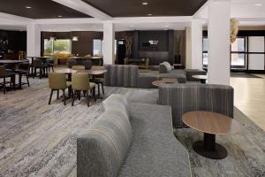 Courtyard by Marriott Houston Rice University في هيوستن: لوبي فيه كنب وطاولات وكراسي