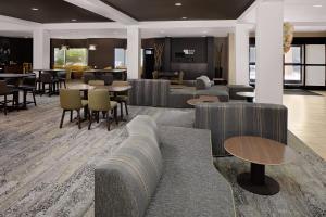 a lobby with couches and tables and chairs at Courtyard by Marriott Houston Rice University in Houston