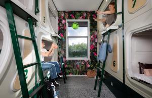 een vrouw in een treinkamer met een raam bij LyLo Christchurch in Christchurch