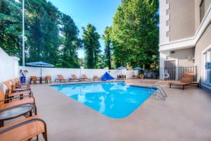 une grande piscine avec des chaises et une clôture dans l'établissement Courtyard Raleigh Crabtree Valley, à Raleigh