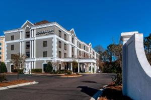 un edificio blanco con un cartel en la parte delantera en Courtyard Raleigh Crabtree Valley, en Raleigh