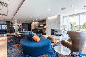 sala de estar con sofá azul y sillas en Fairfield Inn & Suites by Marriott St. Joseph Stevensville, en Stevensville