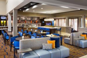 um restaurante com cadeiras e mesas azuis e um bar em Courtyard by Marriott Phoenix North em Phoenix