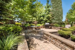 een patio met een tafel en stoelen in een tuin bij Fairfield Inn & Suites – Buffalo Airport in Cheektowaga