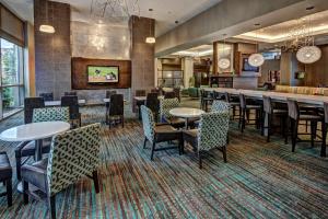 a lobby with tables and chairs and a bar at Residence Inn Norfolk Downtown in Norfolk