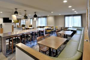 a restaurant with tables and chairs and a bar at Fairfield Inn Greensboro Airport in Greensboro