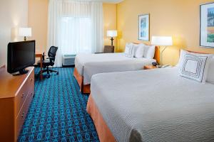 a hotel room with two beds and a flat screen tv at Fairfield Inn & Suites by Marriott Lafayette South in Lafayette