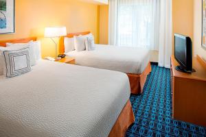 a hotel room with two beds and a flat screen tv at Fairfield Inn & Suites by Marriott Lafayette South in Lafayette