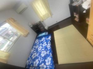 einen Blick über ein Zimmer mit einem Bett und einem Fenster in der Unterkunft ゲストハウス宮崎 guesthouse miyazaki バックパッカー向け個室旅人宿 P有宮崎駅1km喫煙者不可 in Miyazaki