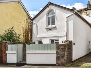 a white house with a gate and a fence at The Old Sail Loft in Torquay