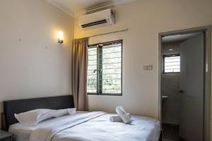 莎阿南的住宿－Double Storey Homestay at Cahaya SPK Shah Alam，一间卧室设有两张床和窗户。