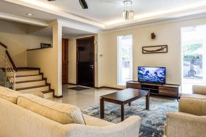 a living room with a couch and a tv at Double Storey Homestay at Cahaya SPK Shah Alam in Shah Alam