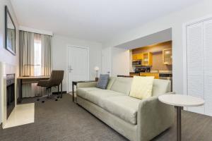 a living room with a couch and a kitchen at Residence Inn Boca Raton in Boca Raton