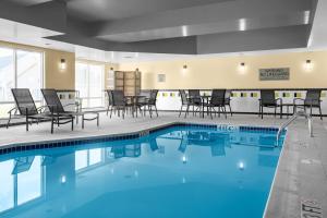 una piscina con sedie e tavoli in una camera d'albergo di Fairfield by Marriott Inn & Suites Columbus Hilliard a Columbus