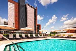 einen Pool mit Stühlen und Sonnenschirmen in einem Hotel in der Unterkunft The Westin Birmingham in Birmingham